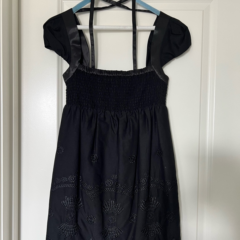 Black detailed dress. It has embroidered detail at the bottom of the dress.